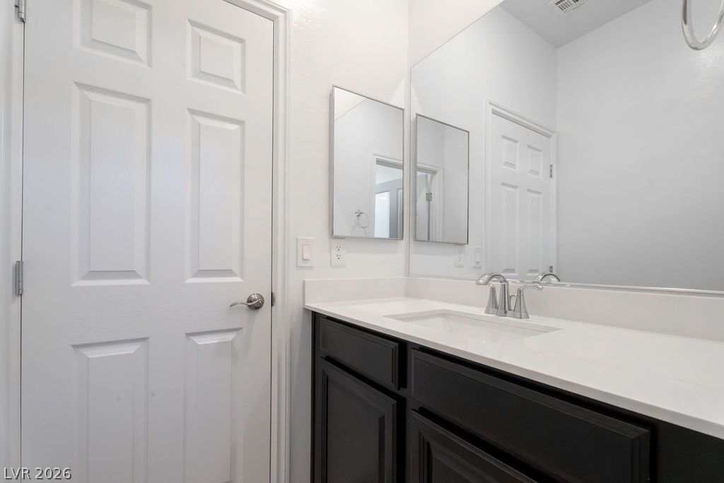 7126 Calvert Cliffs Street North Las Vegas, NV 89084 - Photo 28 of 44 Refined bathroom with a sleek vanity and wall-to-wall mirror for everyday luxury.