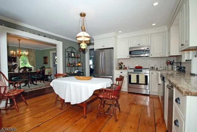 a kitchen with stainless steel appliances white cabinets sink and a window