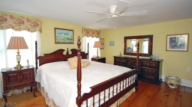 a spacious bedroom with a bed and wooden floor