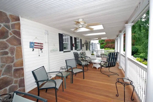 a view of a house with wooden deck and furniture
