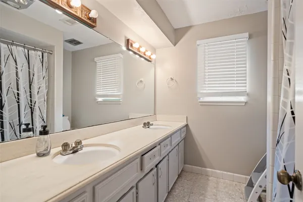 a bathroom with a double vanity sink and a mirror