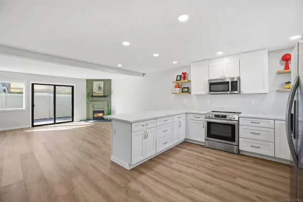 a kitchen with stainless steel appliances granite countertop a stove a sink and a refrigerator