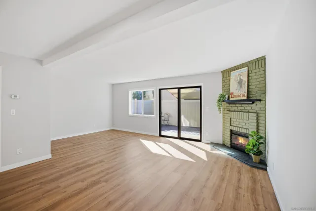 a view of an empty room with a fireplace and a window