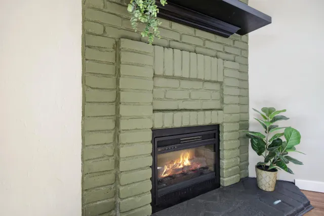 a living room with a fireplace and a potted plant