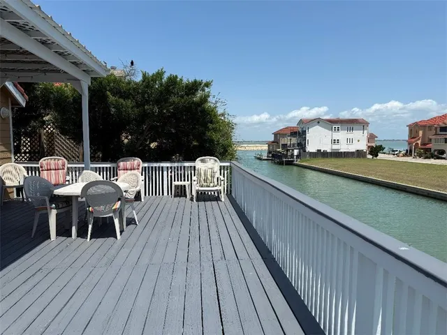 a view of a balcony with wooden floor and iron stairs