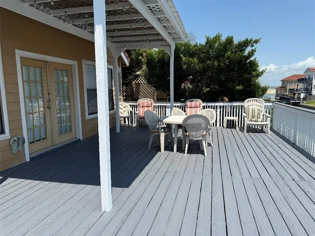 a view of a roof deck with table and chairs with wooden floor and fence