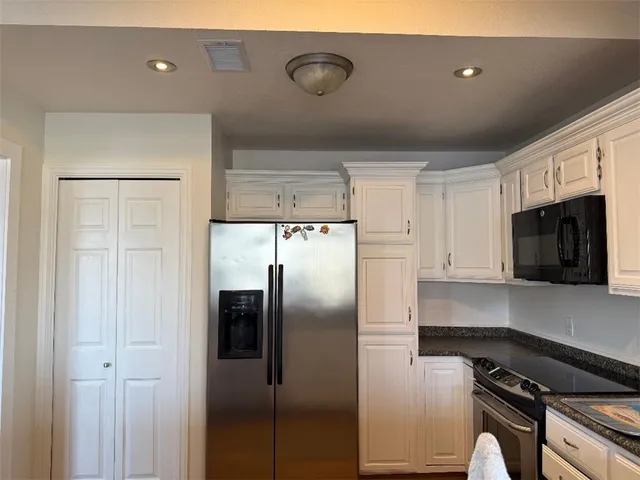 a kitchen with stainless steel appliances granite countertop a refrigerator and a stove top oven