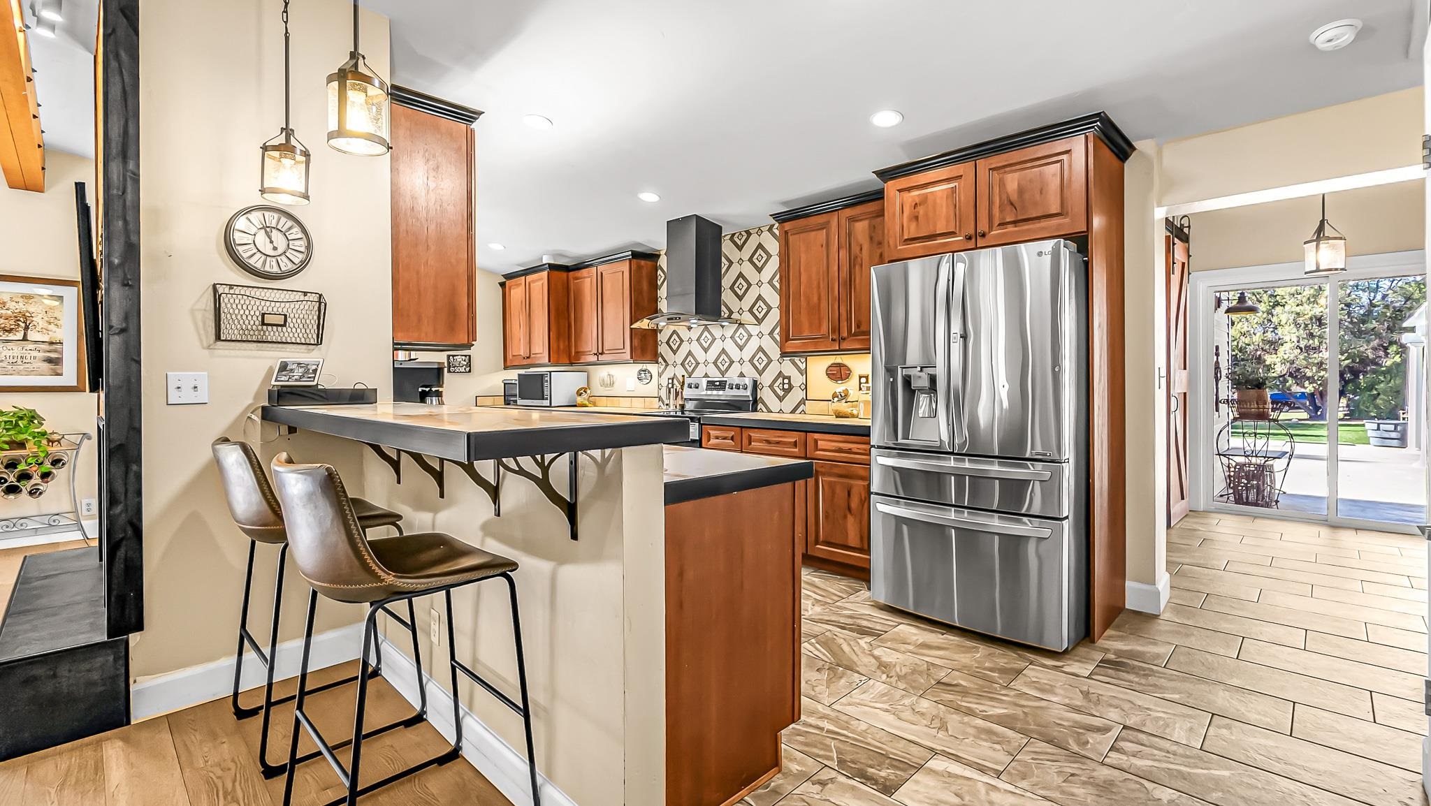 623 26 Road Grand Junction, CO 81505 - Photo 11 of 42 a kitchen with stainless steel appliances granite countertop a refrigerator a stove and white cabinets with wooden floor