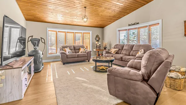 a kitchen with stainless steel appliances granite countertop a refrigerator a stove top oven and a sink with wooden floor