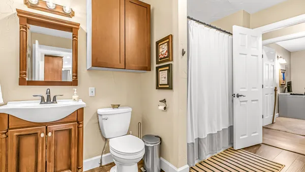 a bathroom with a granite countertop sink mirror and toilet