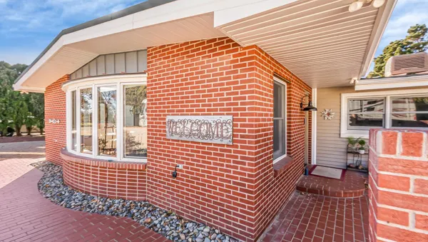 a kitchen with stainless steel appliances granite countertop a refrigerator a stove and white cabinets with wooden floor