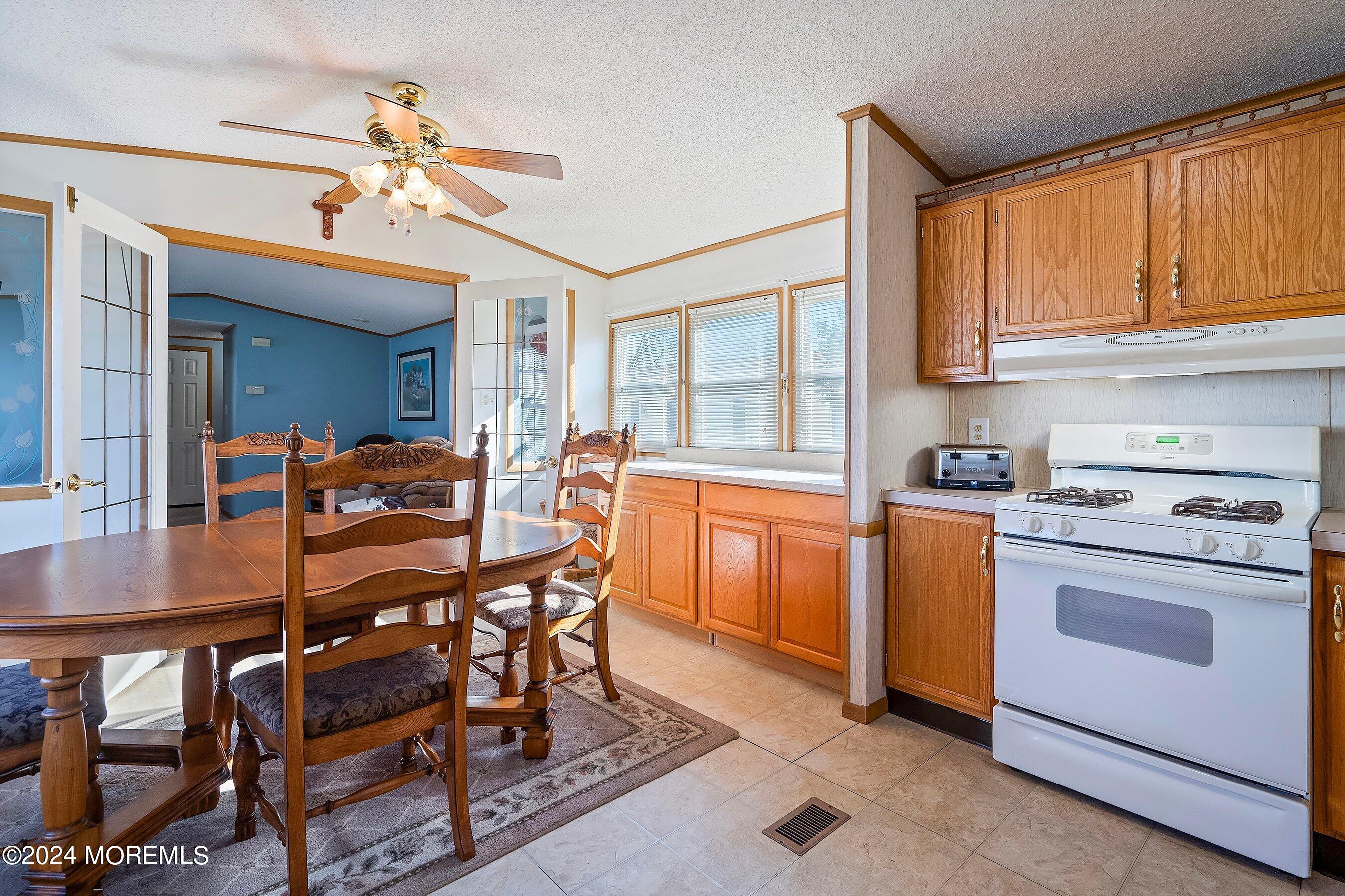 11 Ruffian Way Howell, NJ 07731 - Photo 7 of 17 a dining room with a sink a stove and chairs