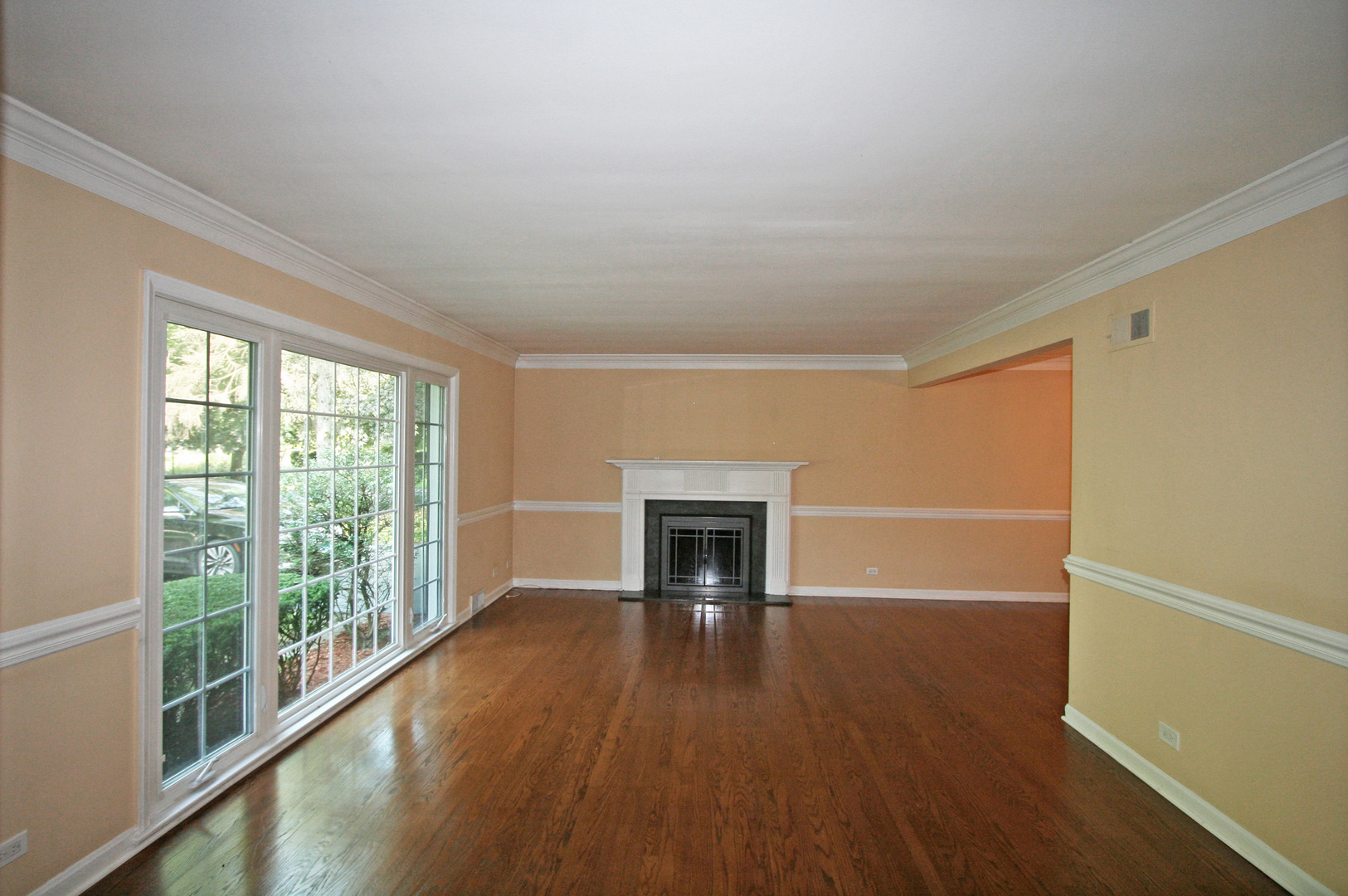 1125 Woodview Road Burr Ridge, IL 60527 - Photo 2 of 22 a view of empty room with wooden floor and fireplace