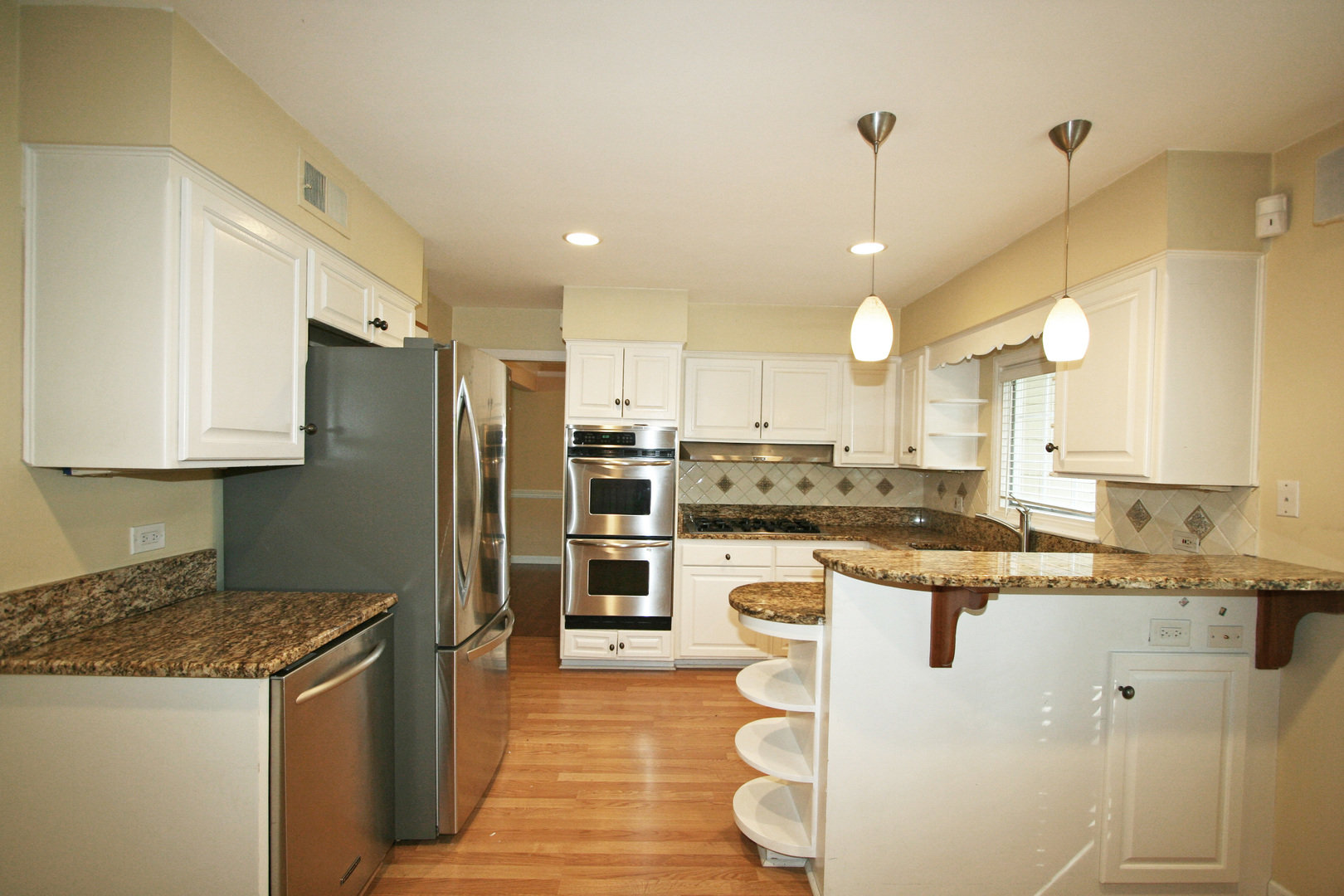 1125 Woodview Road Burr Ridge, IL 60527 - Photo 6 of 22 a kitchen with stainless steel appliances granite countertop a sink a stove a refrigerator and island with wooden floor