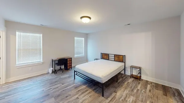 a bedroom with a bed and wooden floor