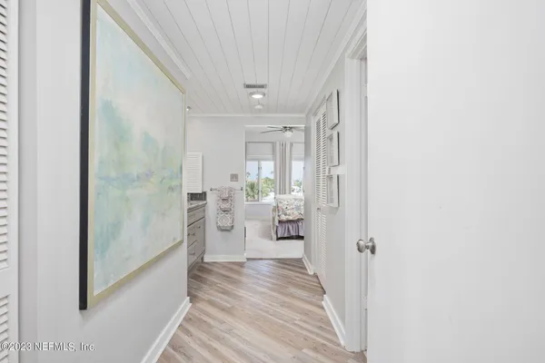 a view of a hallway with wooden floor and a living room