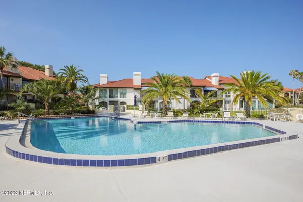 a view of swimming pool with outdoor seating and house in the background
