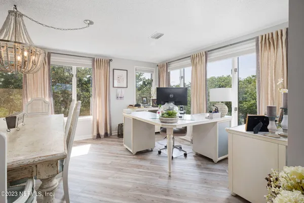 a work room with furniture a large window and wooden floor
