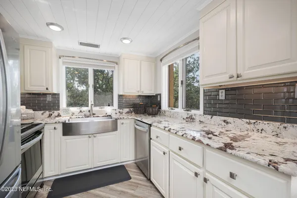 a kitchen with stainless steel appliances granite countertop a stove and cabinets
