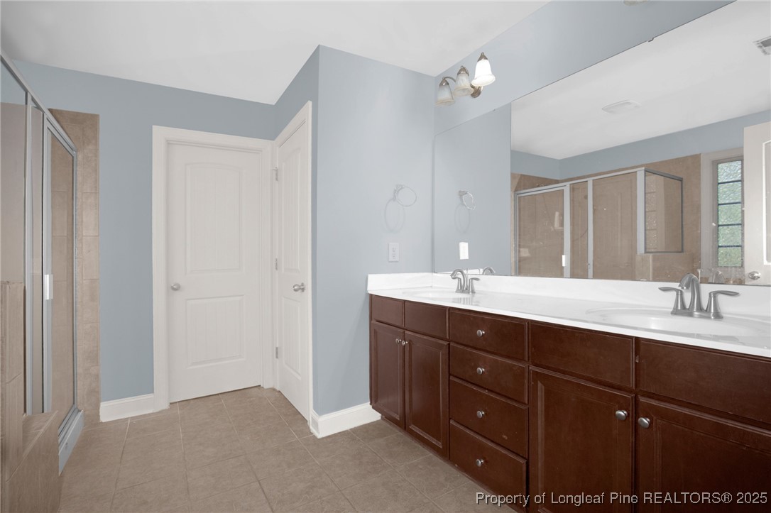 131 Revolutionary Road Cameron, NC 28326 - Photo 34 of 46 a bathroom with a double vanity sink a mirror and a shower