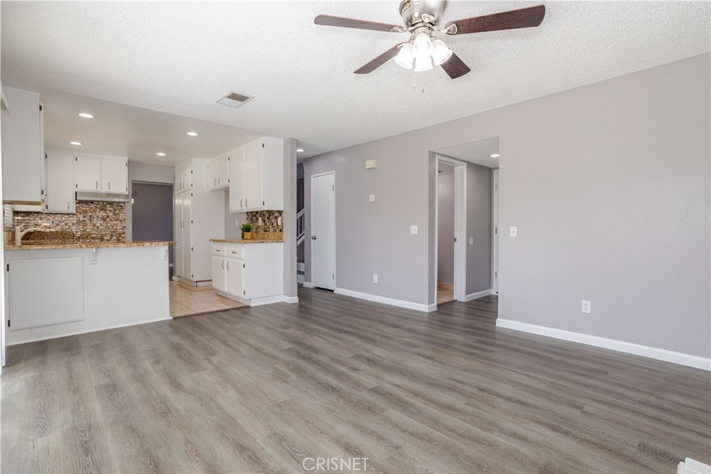 4224 Sorrell Avenue Palmdale, CA 93552 - Photo 12 of 34 a view of an empty room and kitchen with wooden floor