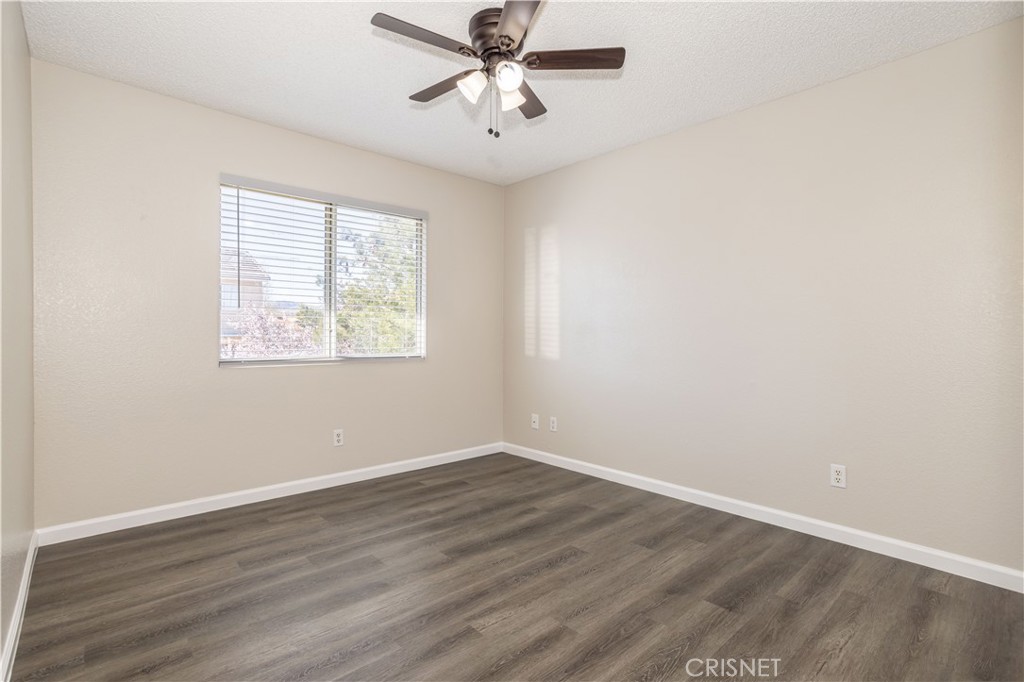 4224 Sorrell Avenue Palmdale, CA 93552 - Photo 13 of 34 an empty room with wooden floor ceiling fan and windows