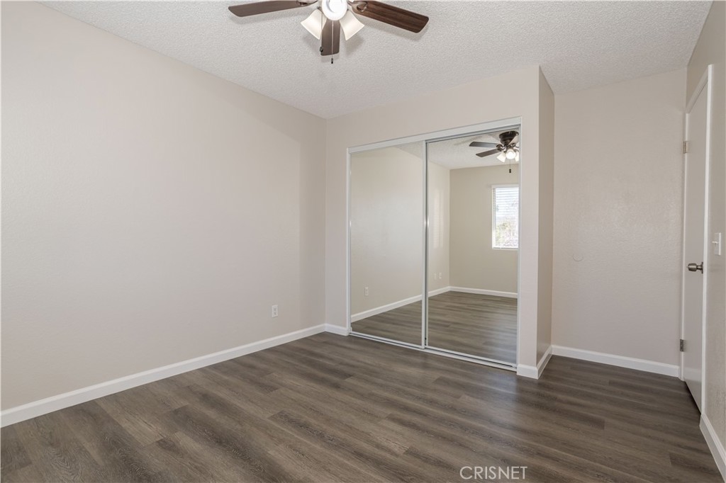 4224 Sorrell Avenue Palmdale, CA 93552 - Photo 14 of 34 an empty room with wooden floor fan and windows