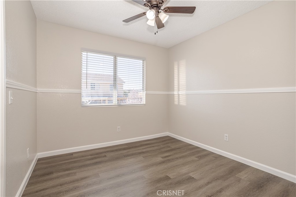4224 Sorrell Avenue Palmdale, CA 93552 - Photo 15 of 34 an empty room with wooden floor and windows