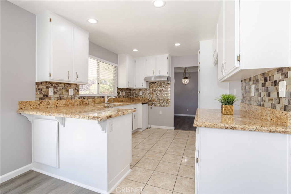 4224 Sorrell Avenue Palmdale, CA 93552 - Photo 8 of 34 a kitchen with stainless steel appliances granite countertop a sink and a refrigerator