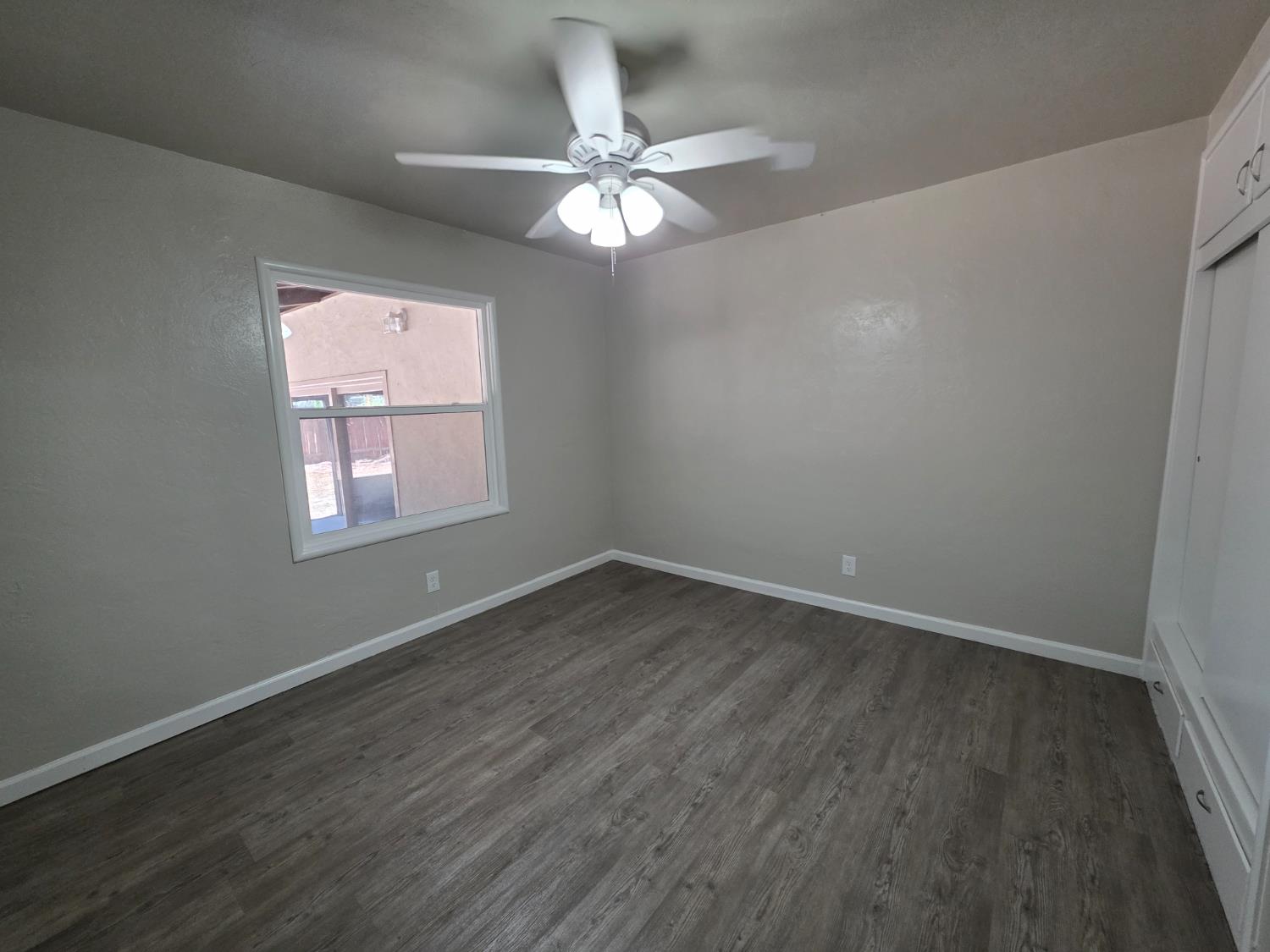 1416 Tully Road Modesto, CA 95350 - Photo 24 of 35 an empty room with wooden floor fan and windows