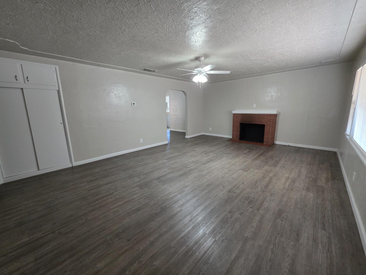 1416 Tully Road Modesto, CA 95350 - Photo 3 of 35 wooden floor in an empty room with a window