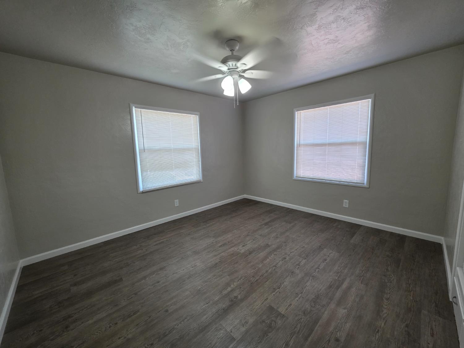 1416 Tully Road Modesto, CA 95350 - Photo 31 of 35 an empty room with wooden floor windows and fan