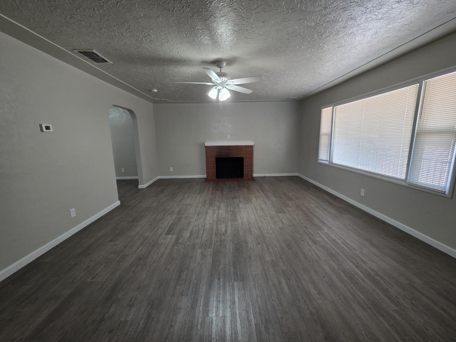 1416 Tully Road Modesto, CA 95350 - Photo 4 of 35 wooden floor in an empty room with a window