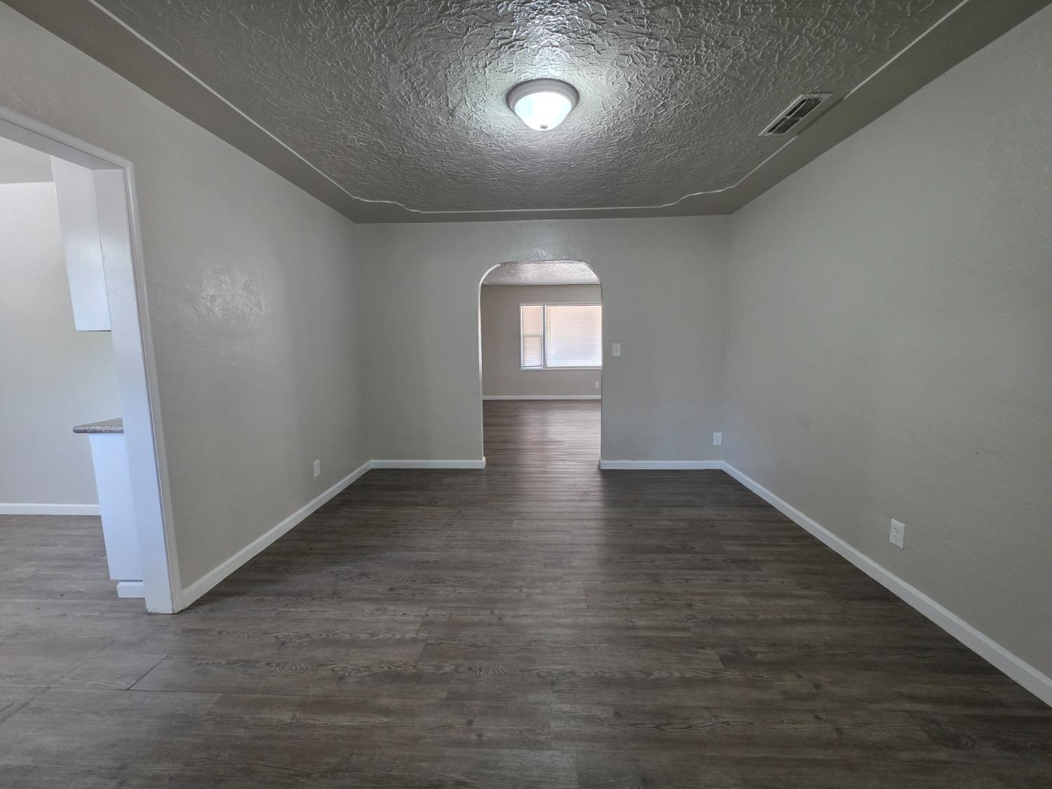 1416 Tully Road Modesto, CA 95350 - Photo 8 of 35 an empty room with wooden floor and windows