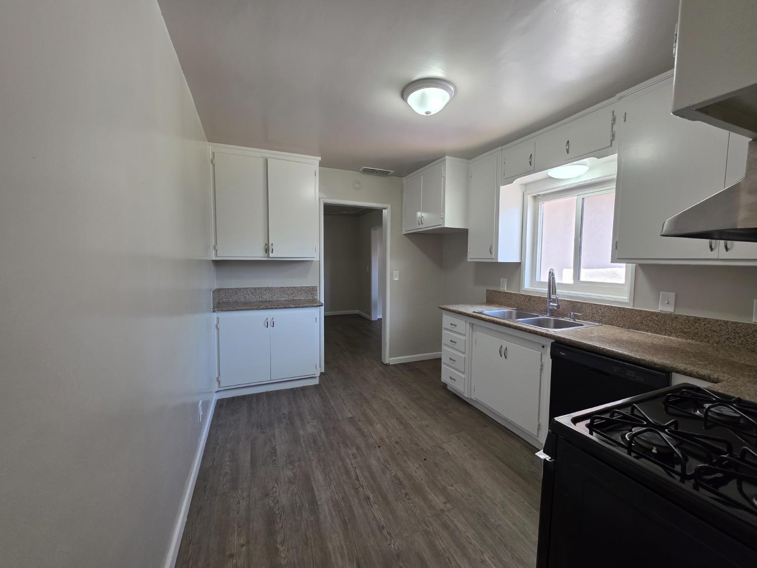 1416 Tully Road Modesto, CA 95350 - Photo 10 of 35 a kitchen with granite countertop a stove a sink dishwasher and a refrigerator with wooden floor