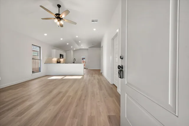 a view of a big room with wooden floor and windows