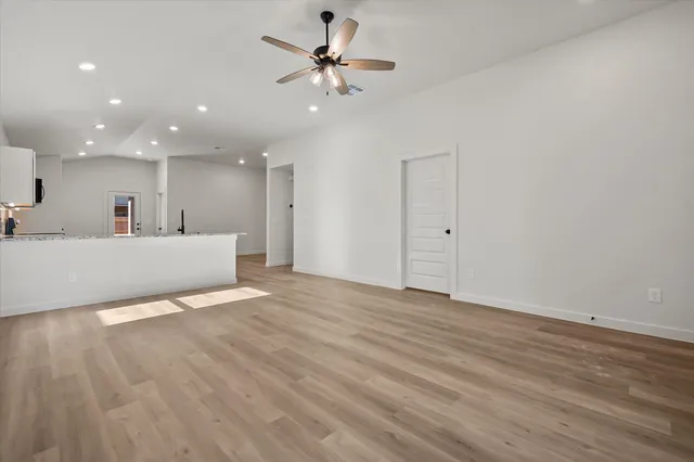 a view of a big room with wooden floor and a ceiling fan