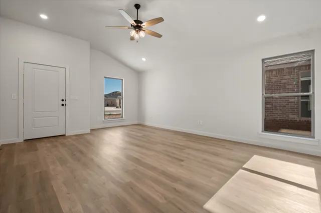 a large kitchen with granite countertop a sink and white cabinets