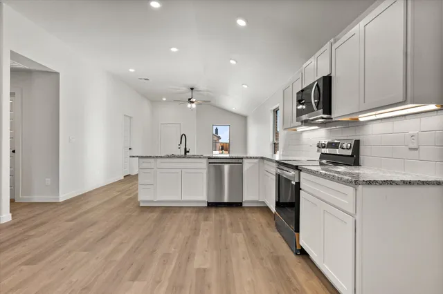 a kitchen with kitchen island granite countertop a stove and a sink