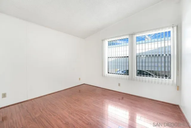 a view of an empty room with wooden floor