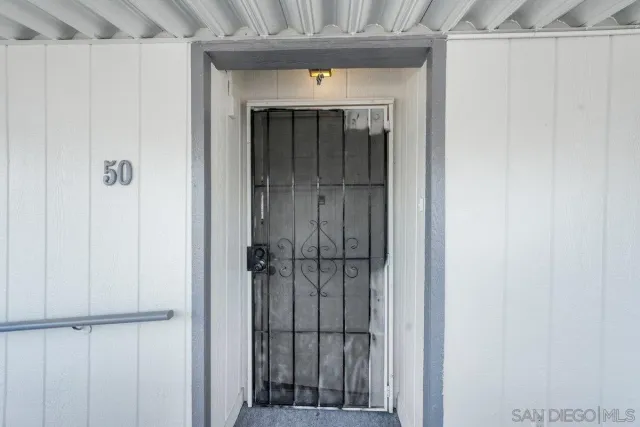 a view of a hallway with wooden floor and a bathroom