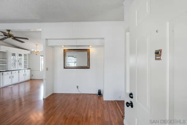 a view of a big room with wooden floor and windows