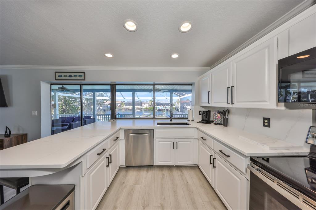 909 Birdie Way Apollo Beach, FL 33572 - Photo 11 of 40 a kitchen with a sink a stove and cabinets