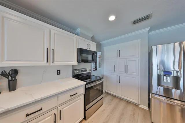 a kitchen with white cabinets and stainless steel appliances