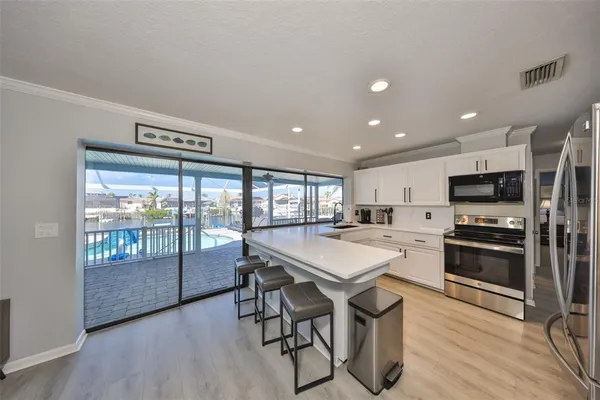 a kitchen with stainless steel appliances a table and chairs in it