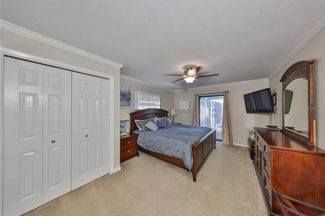 a bedroom with a bed and a flat tv screen on dresser