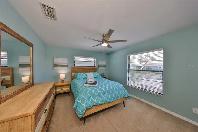 a bedroom with a bed and dresser with mirror