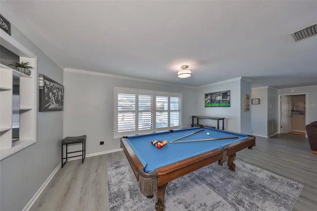 a room with pool table and windows