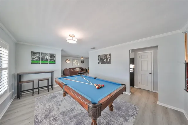 a room with pool table and windows
