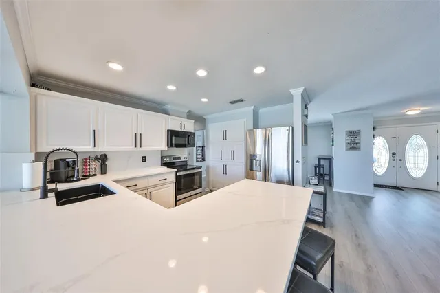 a kitchen with stainless steel appliances a refrigerator sink and cabinets